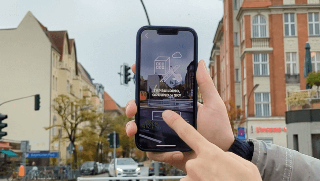 App para dispositivos móveis solicitando que um usuário toque no edifício, no solo ou no céu na tela