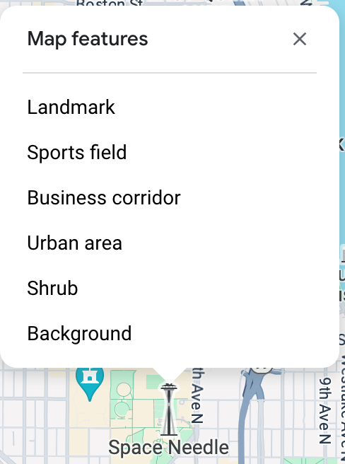 The map inspector opens above the Space Needle and lists six Map Features at that click point: landmark, sports field, business corridor, urban area, shrub, and background.