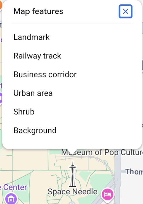 The map inspector opens above the Space Needle and lists six Map Features at that click point: landmark, sports field, business corridor, urban area, shrub, and background.