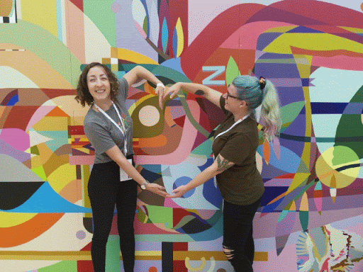 Two people posing for a photo at Google I/O, forming a heart with their arms